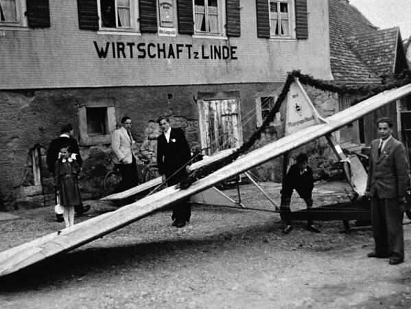 Historischer Blick auf das Gasthaus Linde mit Segelflugzeug im Vordergrund